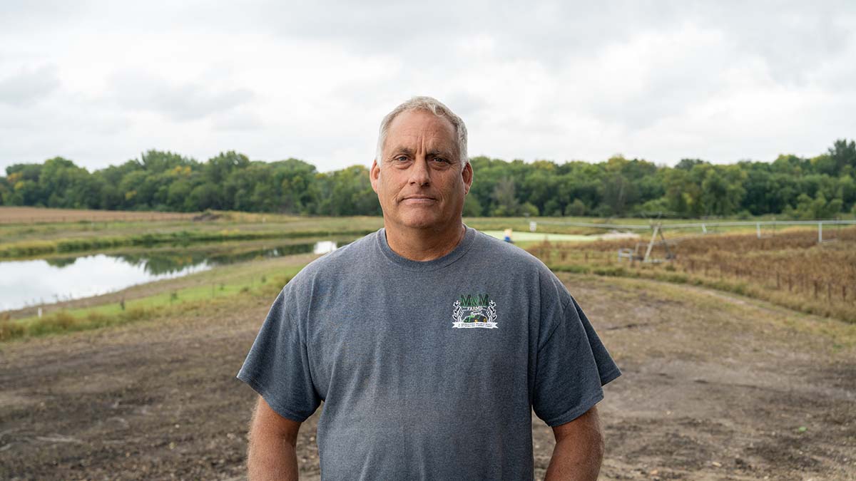 Mark Schleisman standing on his Iowa family farm where he raises pigs